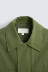 Parka verde militar de corte relaxed fit confeccionada en tejido técnico ligero. Cuello solapa y manga larga. Bolsillos de plastrón con solapa en delantero. Cintura ajustable en interior. Cierre frontal con cremallera oculta por solapa con botones a presión.
