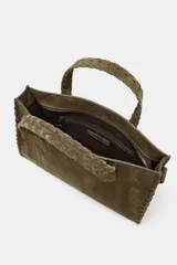 Bolso tipo city bag color verde oliva, confeccionado en piel serraje. Tiene doble asa de mano trenzada y asa bandolera extraíble. Cuenta con detalles metálicos laterales, bolsillo interior con cremallera y cierre principal con cremallera.