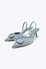 Zapato destalonado color marrón de tejido suave, con punta fina, tacón fino y tira trasera ajustable.