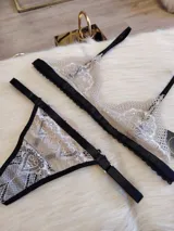 Conjunto de lencería color tostado con detalles en negro, compuesto por un corpiño triangular de encaje con breteles finos y una tanga de encaje con tiras laterales ajustables.