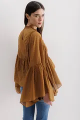 Camisa color marrón con cuello mao, mangas largas abullonadas y detalle de volados en el frente.