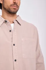 Camisa de manga larga color beige con botones negros.