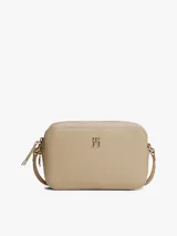 Bandolera Tommy Hilfiger color beige con logo dorado en el frente.