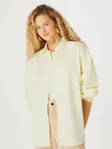 Camisa oversize color amarillo pálido, de manga larga y cuello clásico.