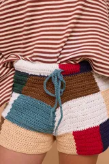 Short tejido a crochet con bloques de colores en tonos beige, marrón, verde, rojo y azul.