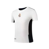 Camiseta de fútbol blanca con detalles en negro, cuello redondo y escudo del Real Madrid en el pecho. Confeccionada en poliéster jacquard en el frente y micro-eyelet en la espalda y mangas.