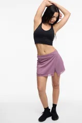 Short deportivo color lila con calza interna y bolsillo lateral. Presenta un frente cruzado y detalle de microtul.