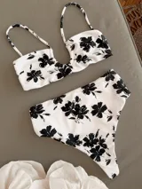 Conjunto de bikini blanco con estampado de flores negras. El corpiño es tipo top con tiras al cuello y la bombacha es de tiro alto.