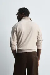 Sweater tipo polo color beige, de punto con mezcla de algodón y lana, corte regular fit, cuello solapa con abertura en V y mangas largas con terminaciones en rib.
