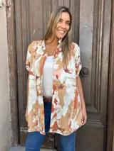 Camisa tipo kimono con estampado abstracto en tonos marrones, naranjas y blancos.