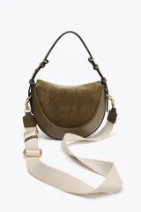 Bolso bandolera ovalado color verde oliva, con solapa de gamuza y asa de cuero ajustable.