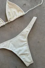 Conjunto de bikini verde esmeralda, con corpiño triangular de atar al cuello y espalda, con almohadillas desmontables, y bombacha colaless con laterales fijos.