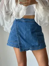 Short pollera de jean azul con corte irregular y detalle de costuras a la vista.