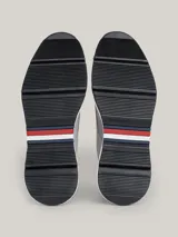 Zapatillas de corte medio color gris claro, con exterior de ante, interior de poliéster reciclado, plantilla extraíble de poliuretano y poliuretano reciclado, suela de goma y caucho, trabilla para calzar distintiva y logo de Tommy Hilfiger en bajo relieve en el lateral y la parte trasera.