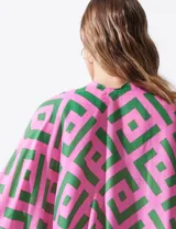 Kimono tejido con estampado geométrico en tonos rosa y verde, con terminación de ruedo con borlas verdes.