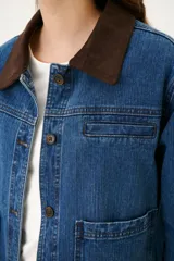Chaqueta de jean azul con cuello de pana color camel, corte recto y bolsillos frontales.