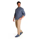 Camisa de manga larga color celeste, con cuello clásico, cierre frontal con botones y bolsillo en el pecho izquierdo con logo de la marca. Las mangas pueden enrollarse y sujetarse con una tira. Corte recto y dobladillo camisero.