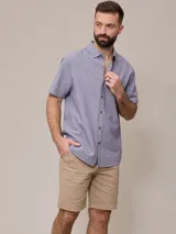 Bermuda color beige, de corte recto y largo hasta la rodilla.