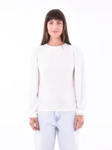 Remera blanca de manga larga con cuello redondo y mangas abullonadas.