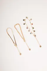 Set de tres pulseras doradas con dije de moneda y dije de flor con centro de color.