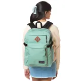 Mochila Jansport Main Campus color verde agua, con logo de la marca en la parte inferior y aplique de cuero sintético en la parte superior. Cuenta con múltiples compartimentos y bolsillos, correas acolchadas y asa de transporte superior.