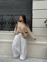 Sweater color beige con cuello redondo y diseño de trenzas en relieve.