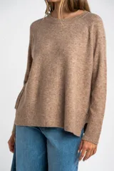 Sweater color marrón claro de tejido de punto, con cuello redondo y mangas largas.