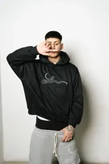 Hoodie negro oversize de algodón con logo bordado en blanco.