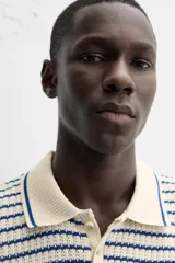 Polo de hombre con corte relaxed fit, cuello solapa con cierre frontal de botonadura y manga corta. Diseño a rayas horizontales en color crema y azul marino.