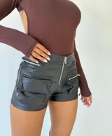 Short de cuero negro, ajustado, con múltiples bolsillos y detalles de cierre.