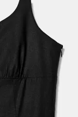Vestido midi negro de lino con escote cuadrado, tirantes finos ajustables, abertura frontal y cierre lateral con cremallera oculta.