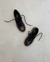 Zapato acordonado negro de cuero vacuno con suela track.