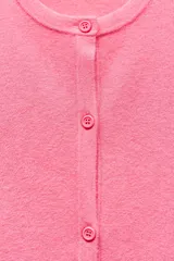 Chaqueta de punto rosa con cuello redondo y manga larga. Cierre frontal con botones.