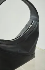 Cartera pequeña de cuero genuino color negro, con forro interno y corte diagonal.