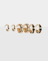 Set de tres pares de aros argolla dorados con diferentes diseños: un par liso, un par texturizado y un par con esmalte negro.
