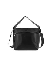 Cartera negra de cuero graneado con doble correa, una de hombro y otra bandolera regulable. Tiene cierre metálico con tirador de cuero, chapita metálica con el logo de la marca y detalles interiores con el logo de la marca y la inscripción "HECHO EN URUGUAY".
