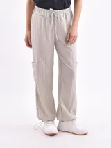 Pantalón color marrón claro, de corte recto, con bolsillos laterales y cordón ajustable en la cintura.