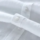 Camisa de lino blanca, de corte ajustado y manga corta, ideal para un look casual.