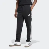 Pantalón de jogging Adidas Essentials con corte clásico, color negro con tres rayas blancas a los costados, cintura elástica con cordón de ajuste, bolsillos frontales y logo bordado.