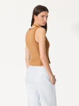 Top marrón de punto con lentejuelas bordadas en el frente, cuello redondo y sisas con terminaciones enrolladas.