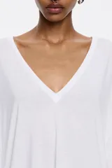 Camiseta blanca de viscosa, corte recto, cuello en V y manga corta ancha.