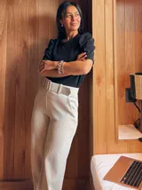 Pantalón de vestir color beige, de corte recto y tiro alto, con cinturón ancho de la misma tela y hebilla rectangular.