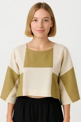 Blusa corta con diseño geométrico en tonos beige y mostaza, de corte holgado y mangas 3/4.