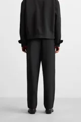 Pantalón negro de corte regular, confeccionado en tejido con viscosa, con cintura elástica, bolsillos frontales y trasero de vivo.