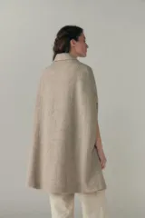 Capa larga color marrón claro con textura tipo tweed, con botones en la parte delantera y bolsillos laterales.