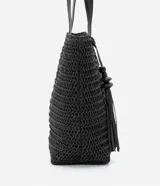 Bolso de playa negro tejido en paja de papel, con asas de hombro en cuero sintético y detalle de borla colgante.