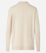 Blusa de punto color crema, con cuello alto y mangas largas.