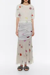 Falda midi gris con estampado floral, corte ajustado, capa superior fruncida en los laterales y capa inferior con vuelo.