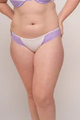 Bombacha de bikini de tiro alto color blanco con laterales de puntilla elastizada color lila.