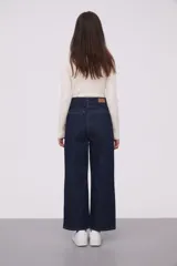 Pantalón de jean azul oscuro, de corte recto y tiro alto, con bolsillos delanteros y traseros de parche.